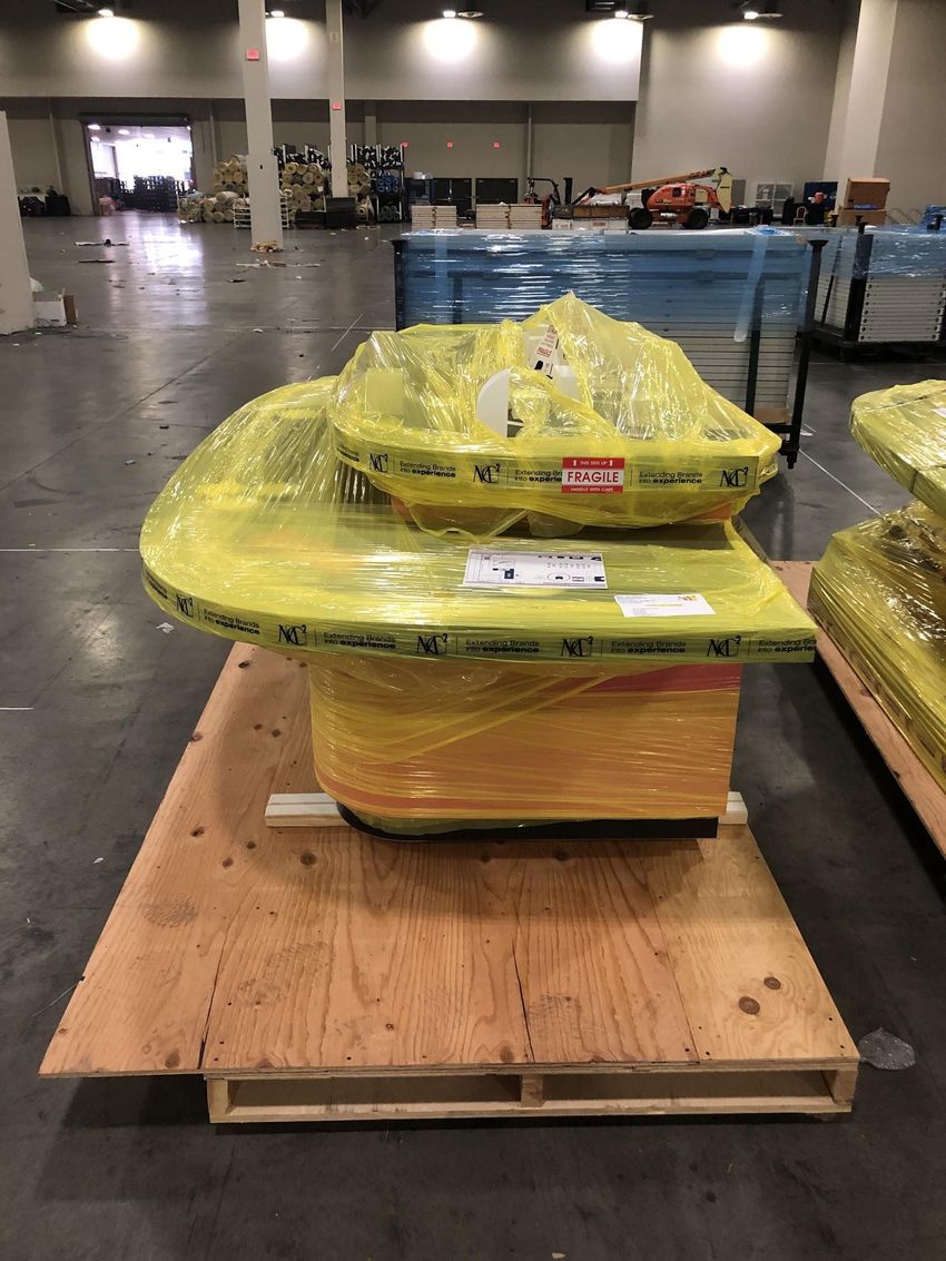 A wheeled half of the model shrink-wrapped and labeled fragile on a wooden skid, ready for transport